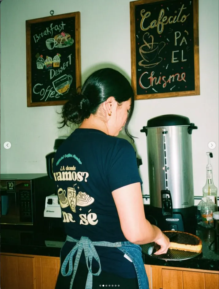 Barista preparando un pedido junto a la pizarra 'Cafecito pa'l chisme'