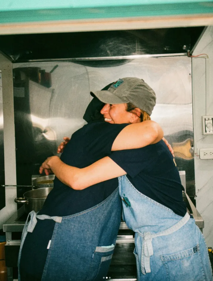 Dos compañeras de cocina dándose un abrazo